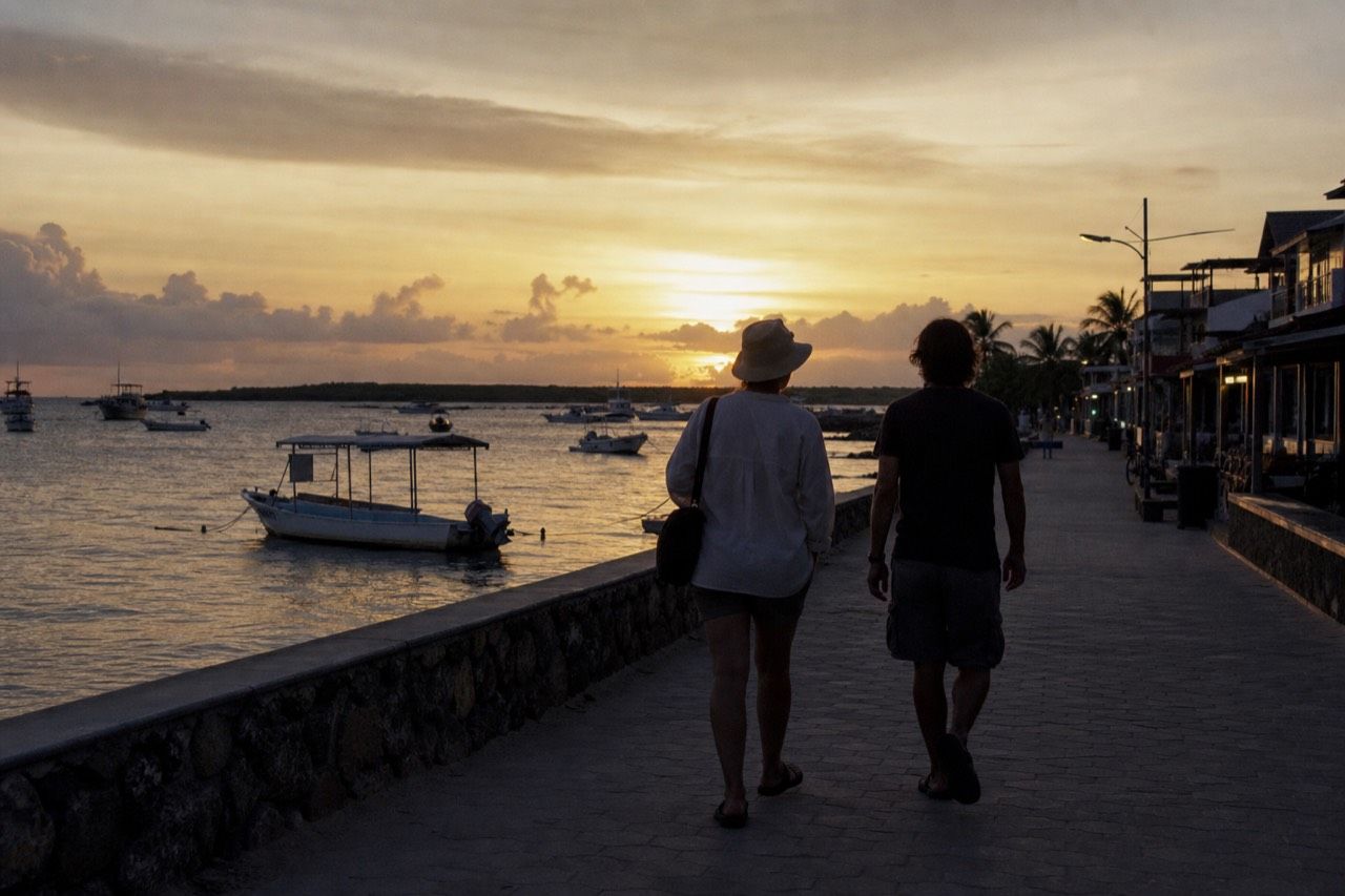 Waterfront street in Puerto Ayora on Santa Cruz Island with visitors walking past small hotels and cafes