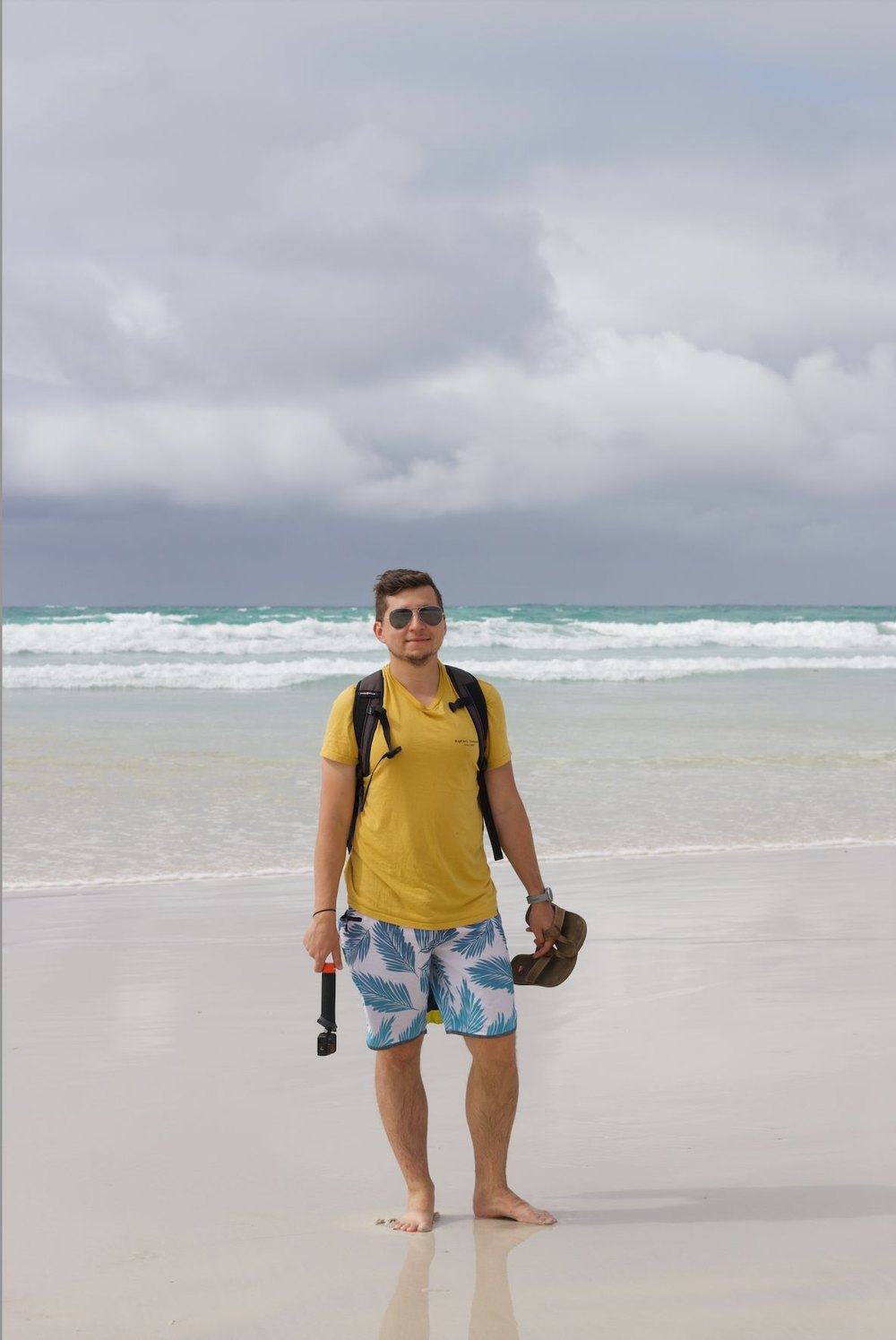 Oleg Galeev standing on the white sand at Tortuga Bay, Santa Cruz Island, Galapagos